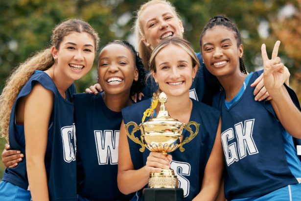 Trophy, sports and winner women team celebration portrait for international netball competition or