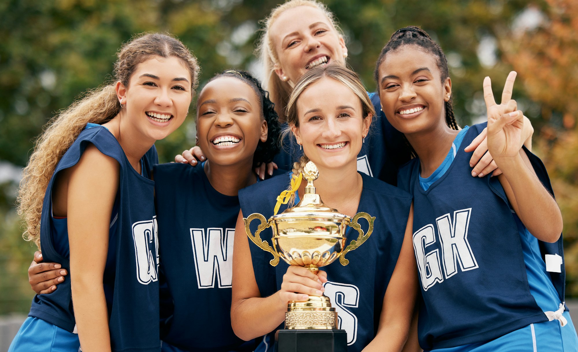 Trophy, sports and winner women team celebration portrait for international netball competition or